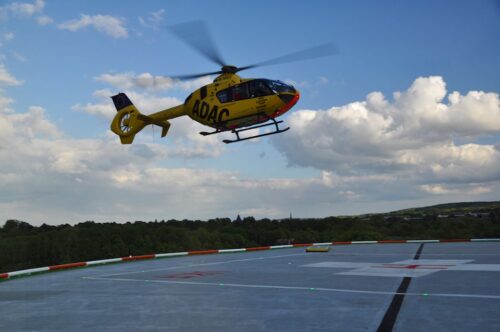 ADAC helicopter taking off from a heliport illuminated with Aerolighting products.
