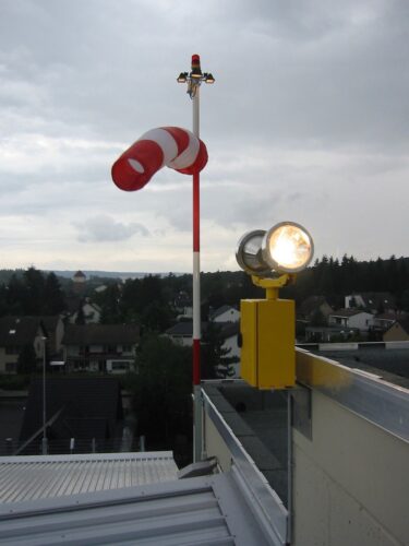 rotating beacon installed next to a wind direction indicator